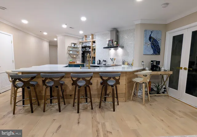 a kitchen with stainless steel appliances granite countertop table chairs stove and cabinets