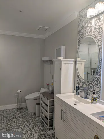 a bathroom with a granite countertop sink mirror vanity and toilet