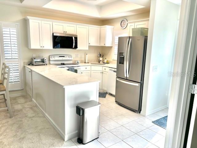 8369 Wingate Drive, Unit 2114 Sarasota, FL 34238 - Photo 3 of 26 a kitchen with a refrigerator a microwave a sink and a stove