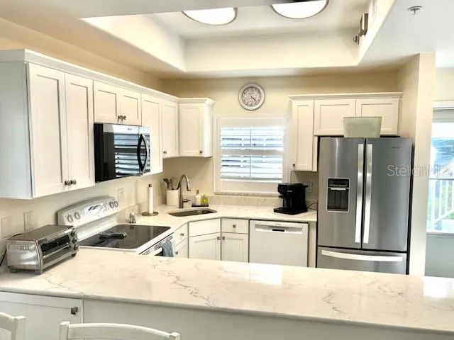 a kitchen with a sink a refrigerator and a stove top oven