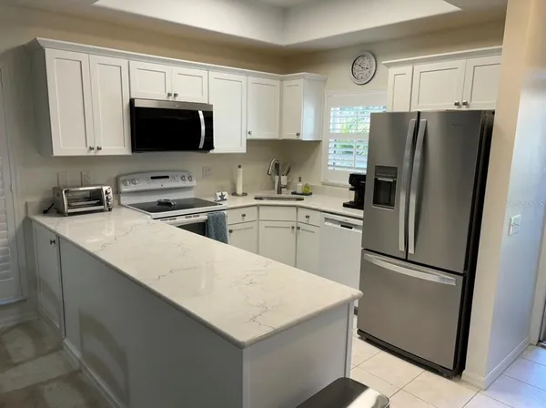 a kitchen with a sink a microwave a refrigerator and cabinets