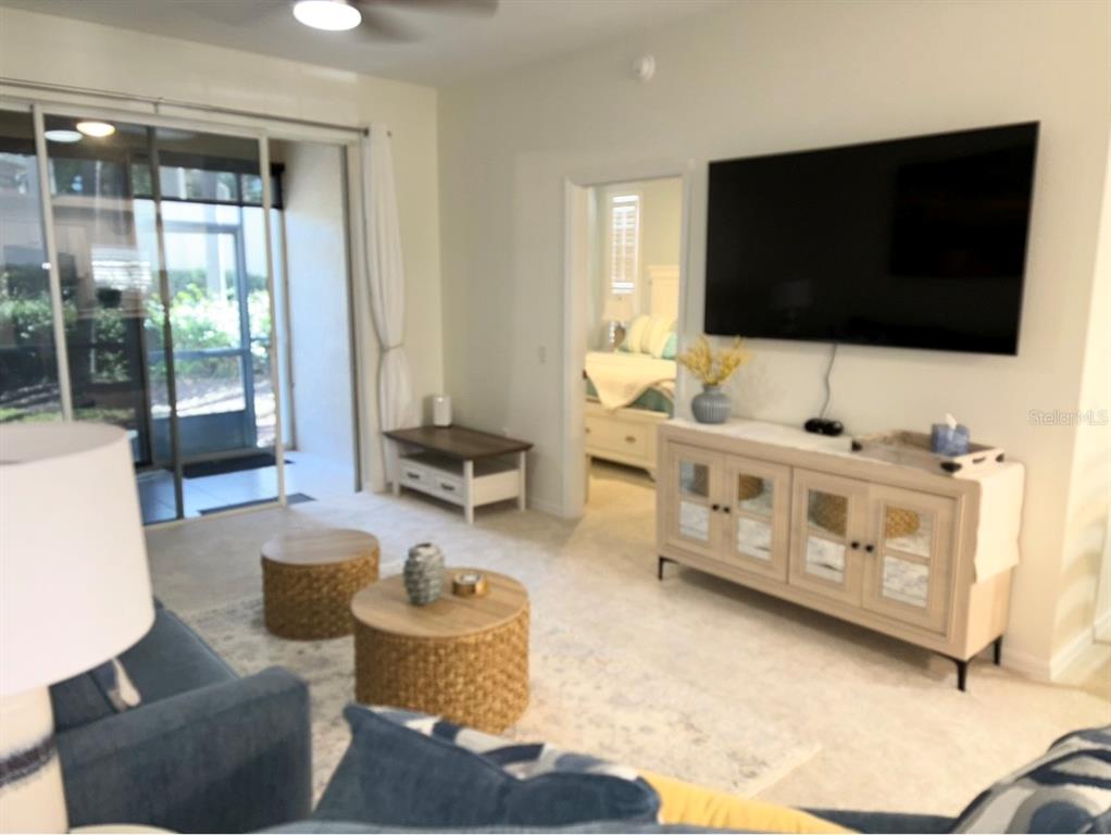 8369 Wingate Drive, Unit 2114 Sarasota, FL 34238 - Photo 9 of 26 a living room with furniture and a flat screen tv