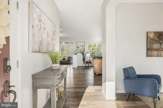 a living room with furniture and a large window with kitchen view