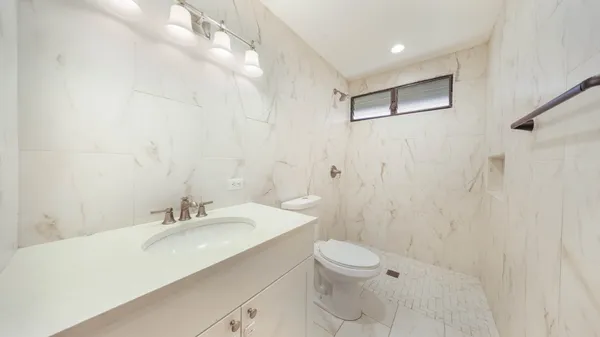 a bathroom with a sink a toilet and shower