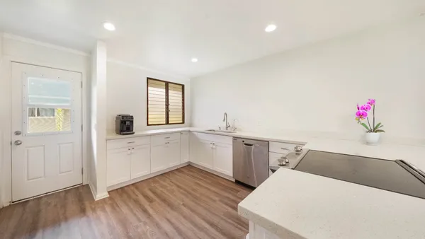 a view of a kitchen with wooden floor and electronic appliances