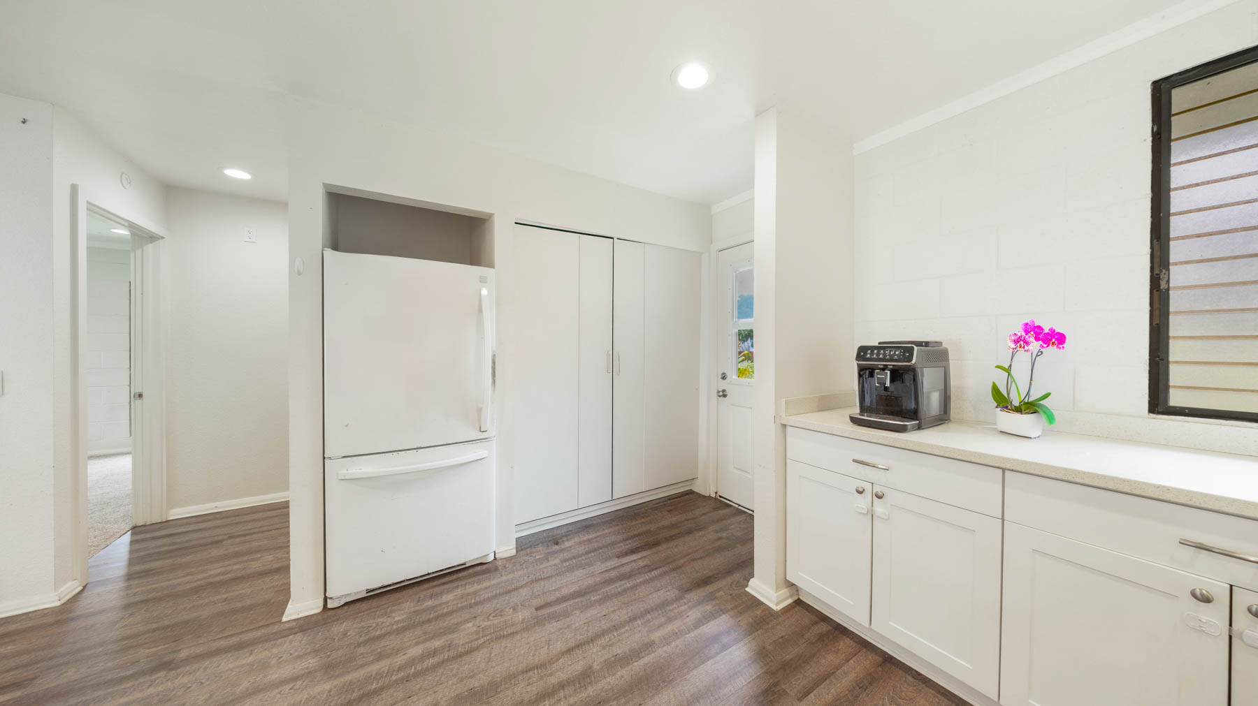 328 Molo Street Kapaa, HI 96746 - Photo 9 of 30 a kitchen with white cabinets and wooden floor