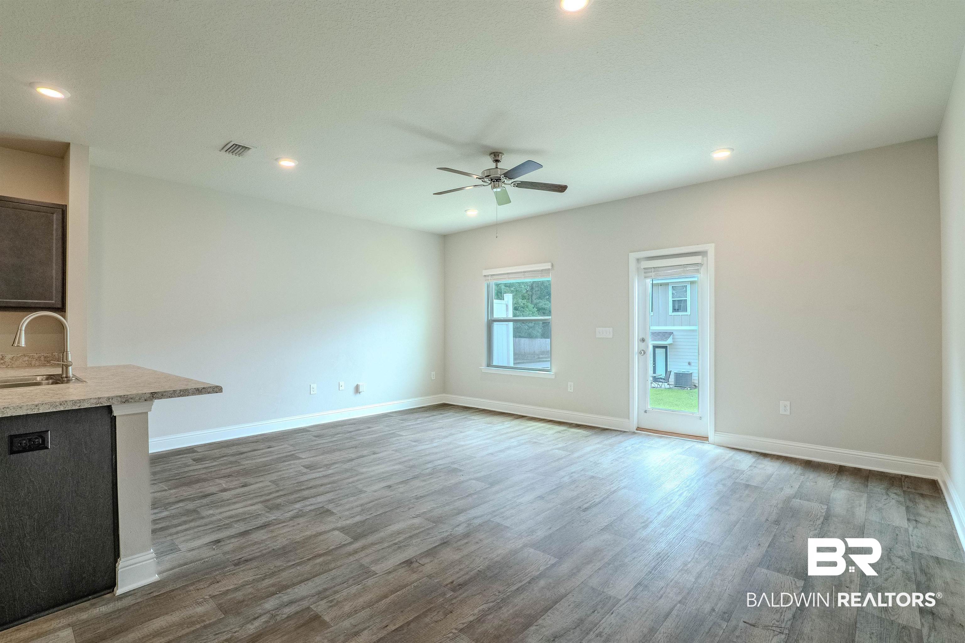 25806 Pollard Road, Unit 32 Daphne, AL 36526 - Photo 7 of 23 Unfurnished living room with ceiling fan, sink, and wood-type flooring