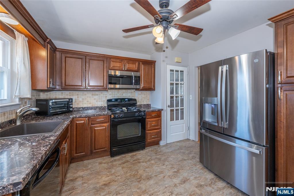 54 Harrison Street Dumont, NJ 07628 - Photo 11 of 35 a kitchen with stainless steel appliances granite countertop a refrigerator stove microwave and sink
