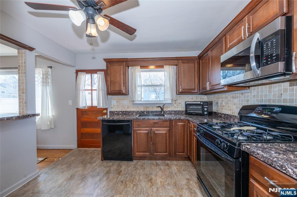 54 Harrison Street Dumont, NJ 07628 - Photo 12 of 35 a kitchen with stainless steel appliances granite countertop a stove a sink dishwasher and a microwave oven with cabinets
