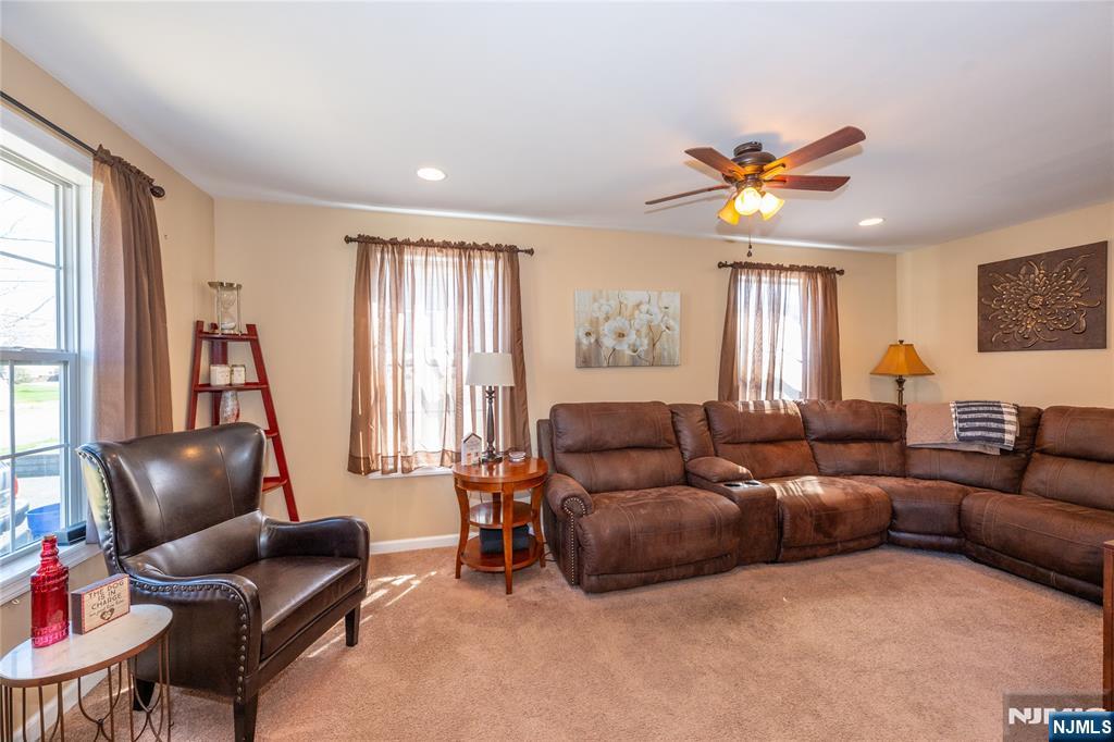 54 Harrison Street Dumont, NJ 07628 - Photo 14 of 35 a living room with furniture a ceiling fan a fireplace and a window