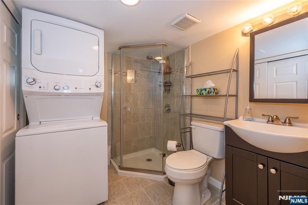 54 Harrison Street Dumont, NJ 07628 - Photo 24 of 35 a bathroom with a toilet sink vanity and mirror