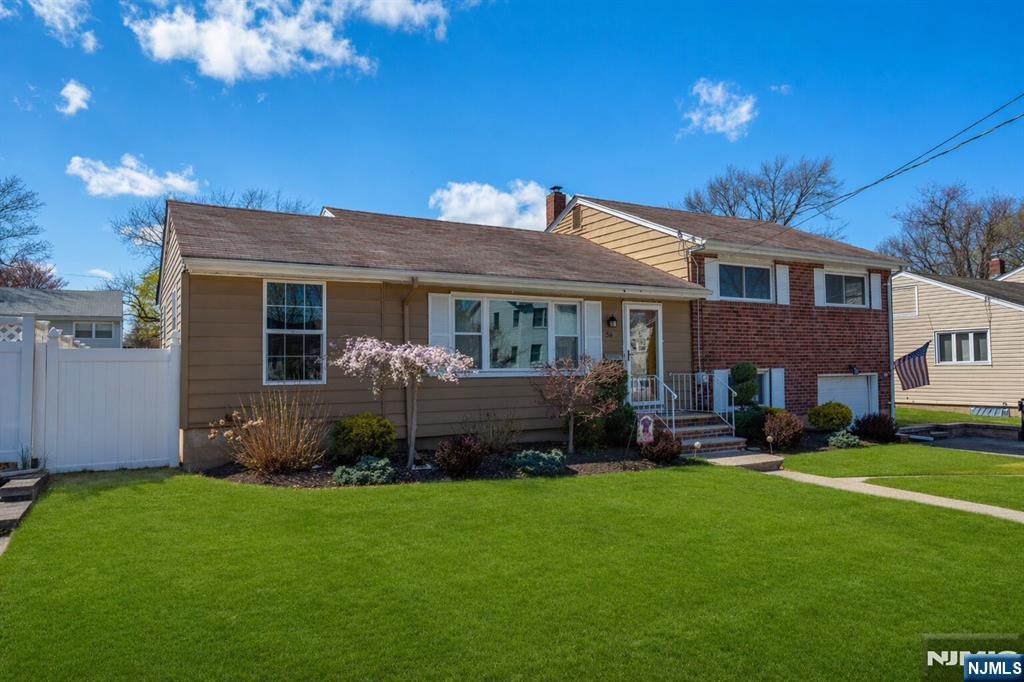 54 Harrison Street Dumont, NJ 07628 - Photo 3 of 35 a front view of a house with a garden and plants