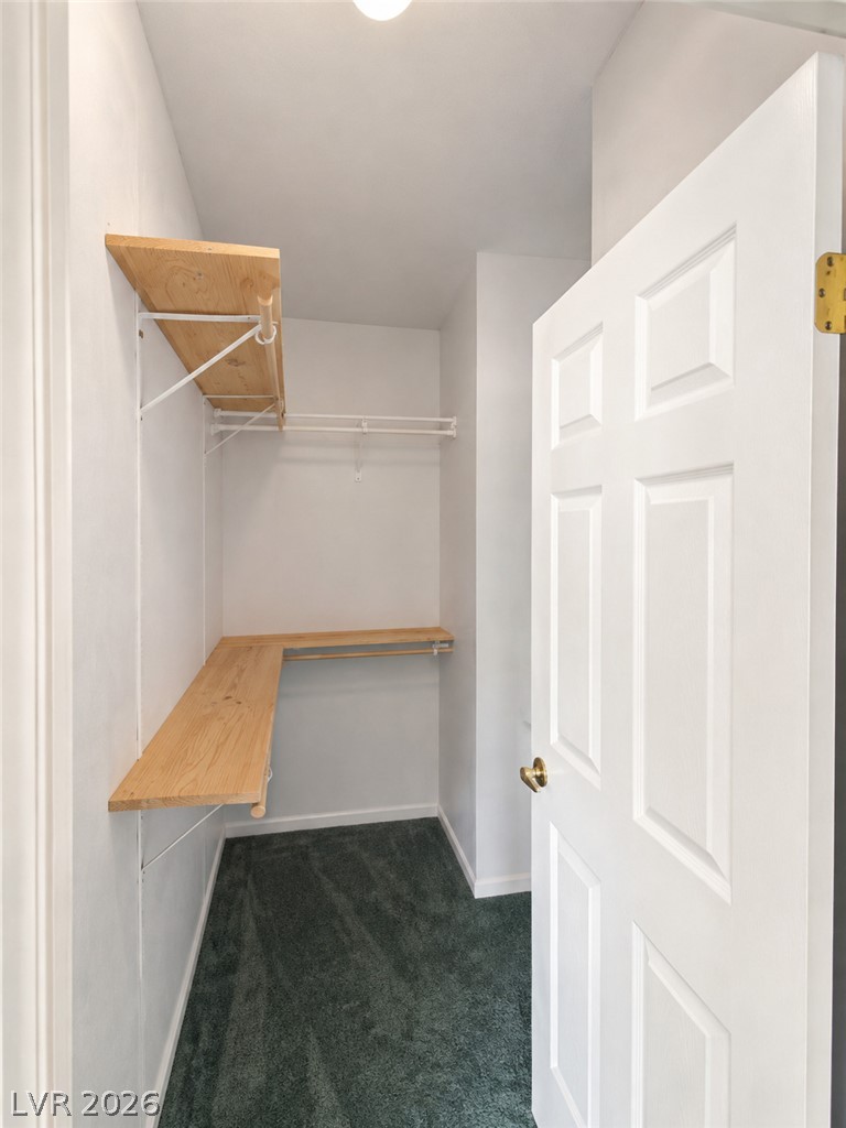 5561 Doubletree Road Pahrump, NV 89061 - Photo 11 of 19 Custom wooden shelving and plush carpeting maximize storage efficiency in this closet space.