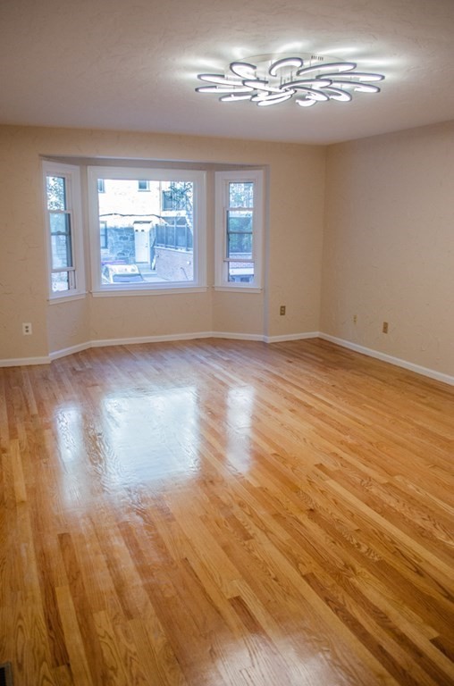 44 Regent Circle, Unit 44 Brookline, MA 02445 - Photo 3 of 10 a view of empty room with wooden floor and fan