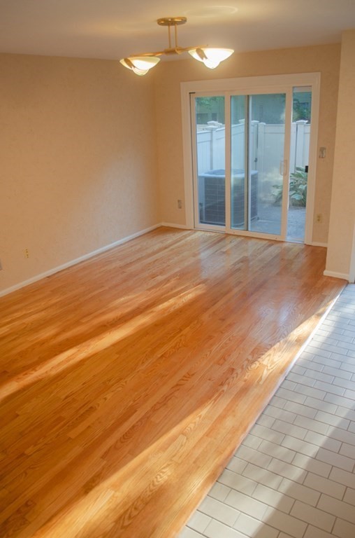 44 Regent Circle, Unit 44 Brookline, MA 02445 - Photo 4 of 10 a view of an empty room with window and wooden floor