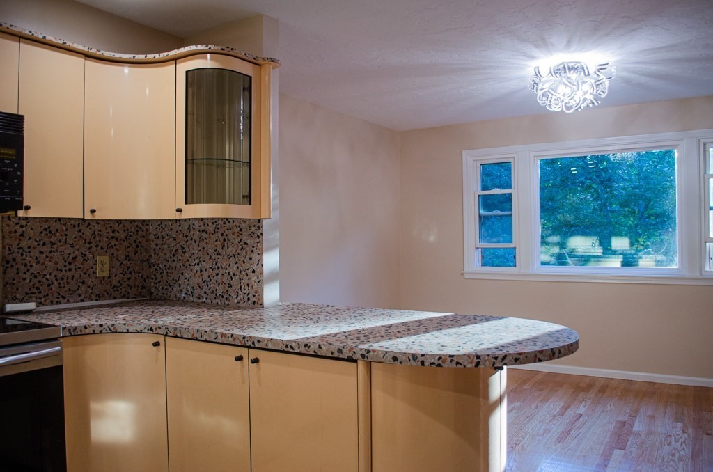 44 Regent Circle, Unit 44 Brookline, MA 02445 - Photo 8 of 10 a kitchen with granite countertop a sink a stove cabinets and wooden floor