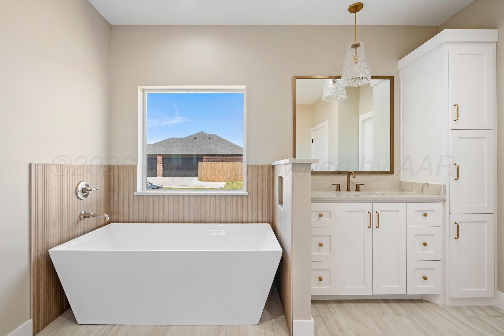 4201 Juniper Springs Road Amarillo, TX 79119 - Photo 18 of 27 a bathroom with a sink a mirror and a bathtub