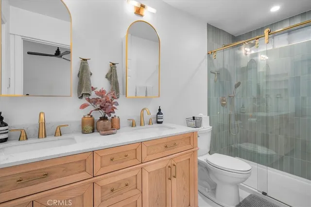 a bathroom with a granite countertop sink a toilet and a mirror
