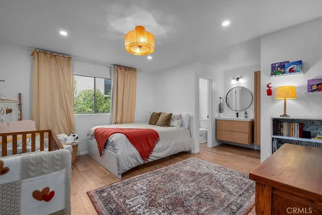 a bedroom with a bed a dresser and next to a window