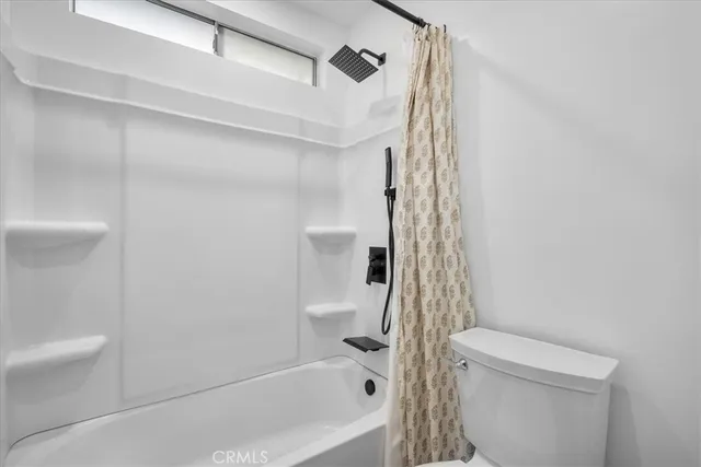 a bathroom with a shower a toilet and a bathtub