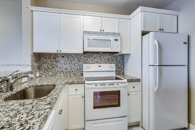 a kitchen with a stove a refrigerator and a sink