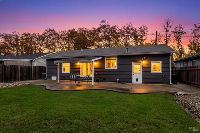 a view of a backyard with table and chairs and wooden fence
