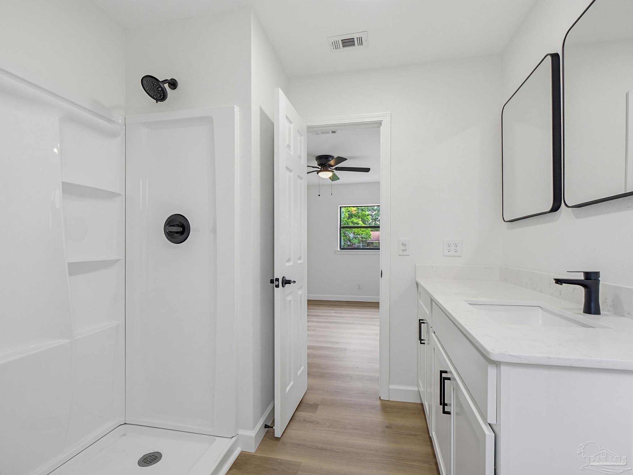125 Madrid Road Cantonment, FL 32533 - Photo 7 of 16 a bathroom with a sink a mirror and shower