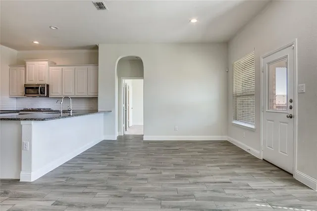 a view of kitchen with wooden floor and electronic appliances