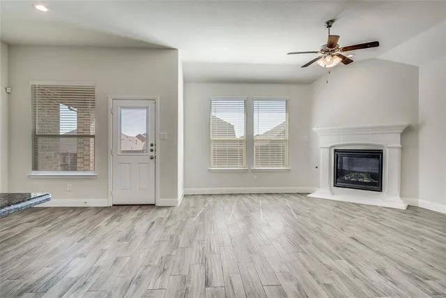 wooden floor fireplace and windows in an empty room