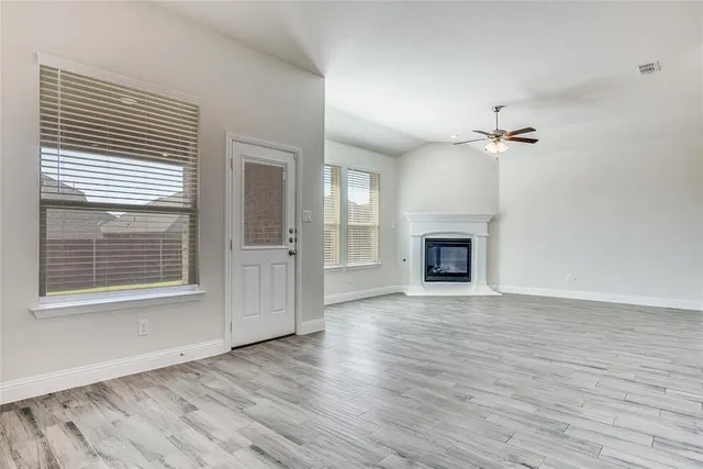 a view of an empty room with a fireplace and a window