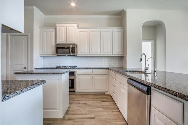 a kitchen with stainless steel appliances granite countertop a sink stove and cabinets
