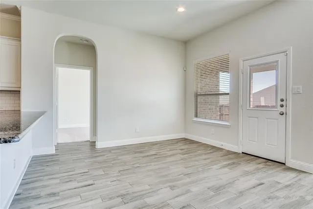 an empty room with wooden floor and a window