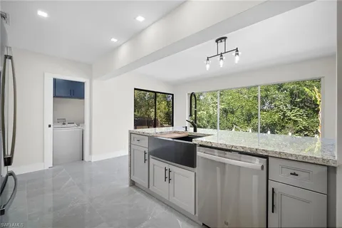 a kitchen with kitchen island granite countertop a stove top oven microwave and sink