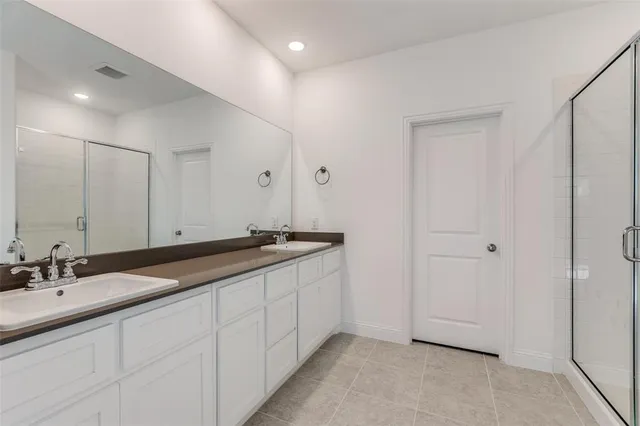 a bathroom with double sink and a mirror