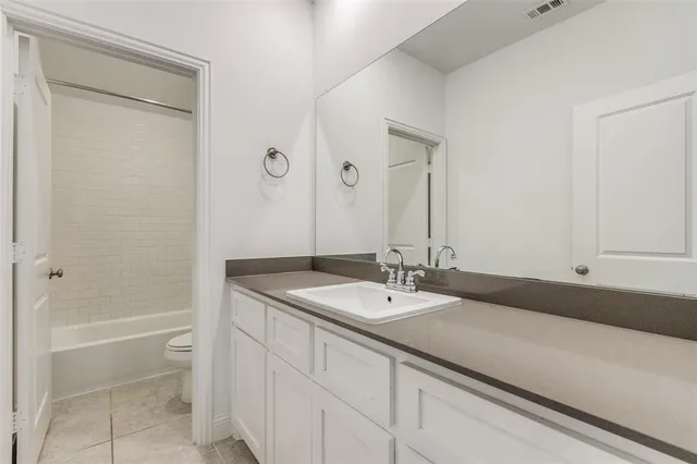 a bathroom with a granite countertop sink a toilet and shower