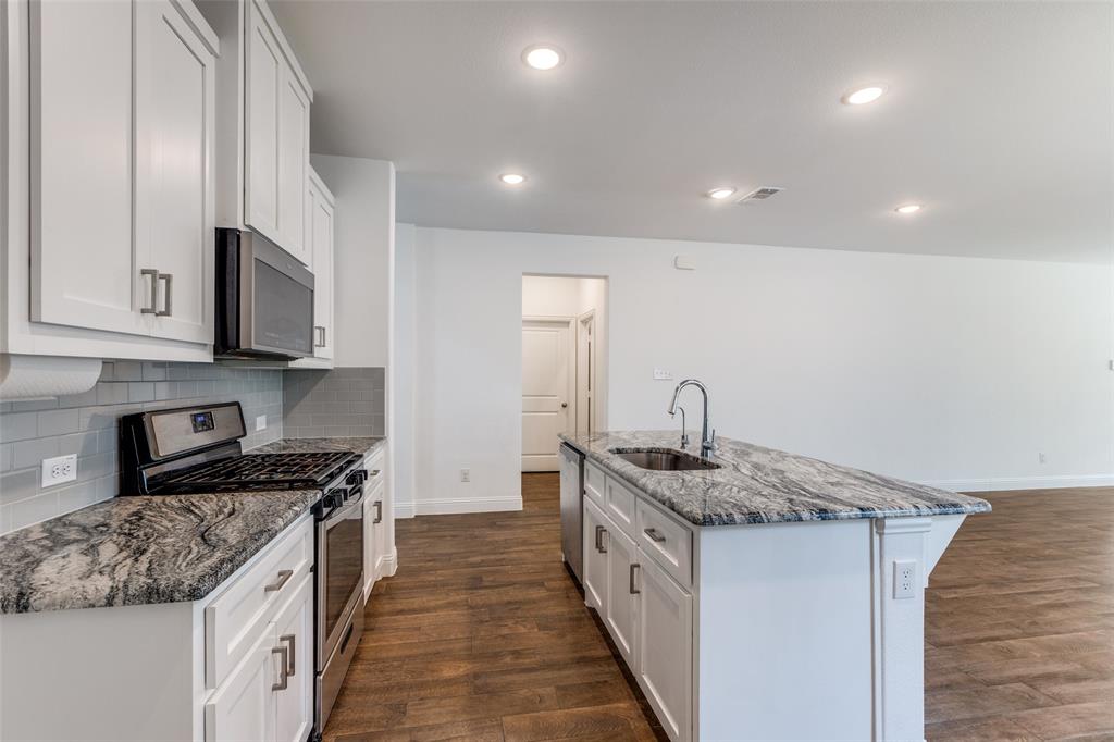 1400 Elizabeth Street Anna, TX 75409 - Photo 10 of 25 a kitchen with stainless steel appliances granite countertop a sink stove and cabinets
