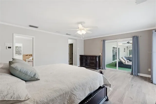 an empty room with wooden floor and ceiling fan