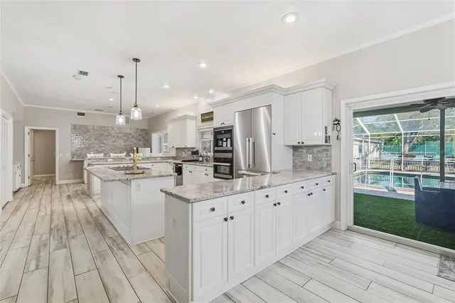 a large room with chandelier fan and wooden floor