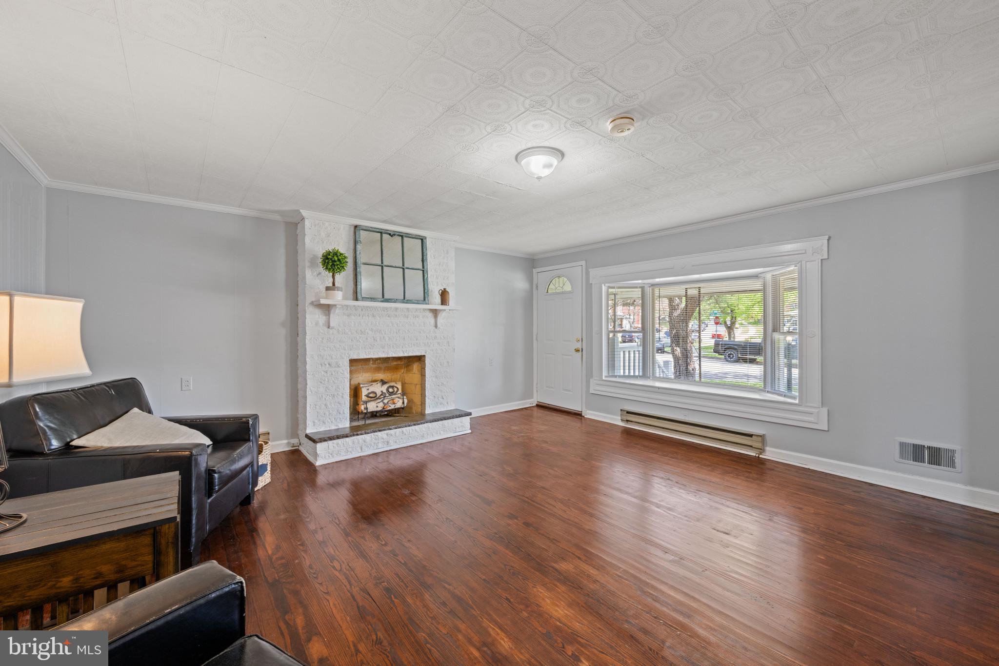 301 3rd Street Baltimore, MD 21206 - Photo 7 of 25 a view of an empty room with a fireplace and a window