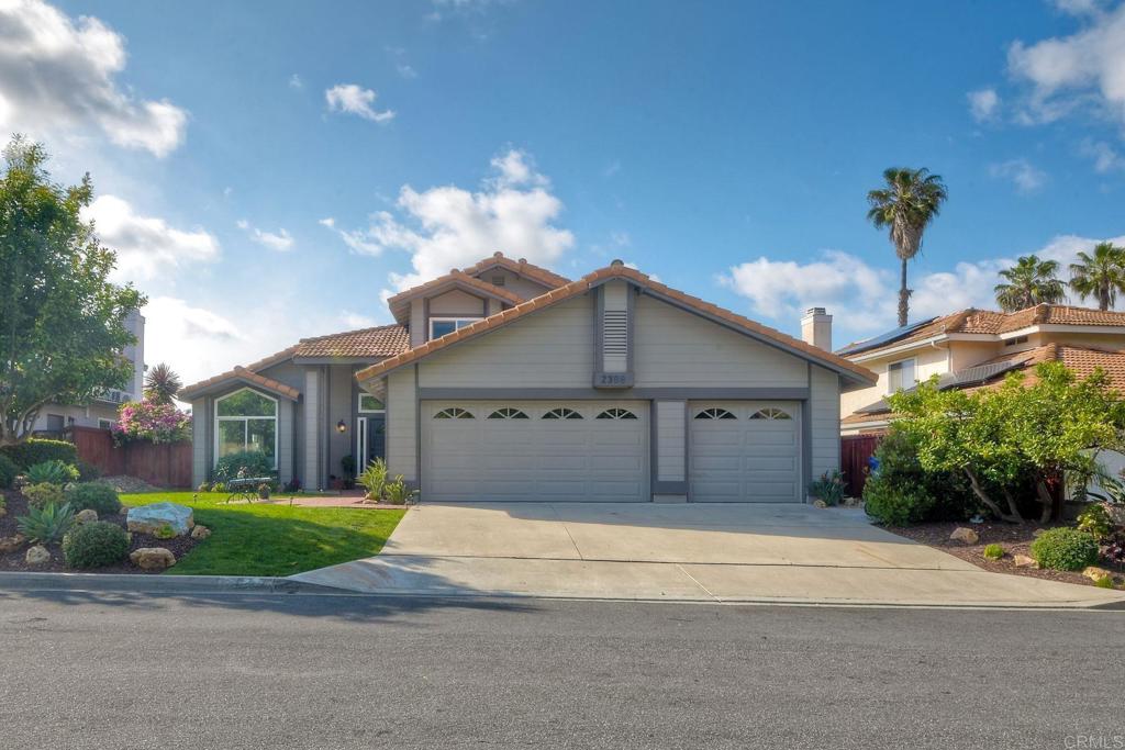 a front view of a house with a yard and potted plants