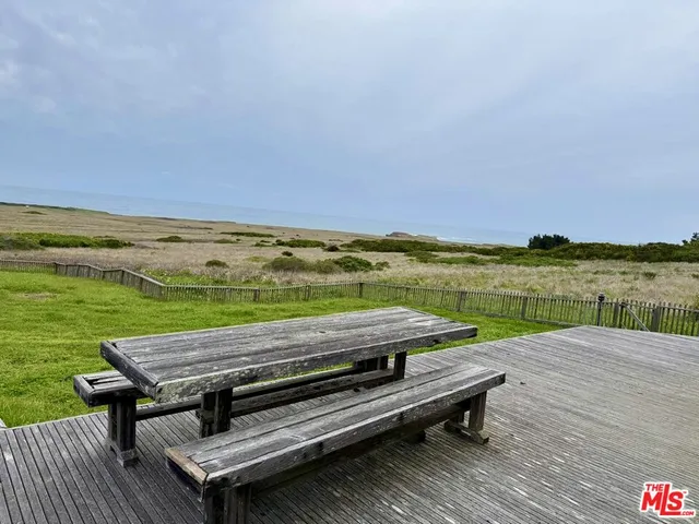 a view of a wooden deck with lake and mountain view