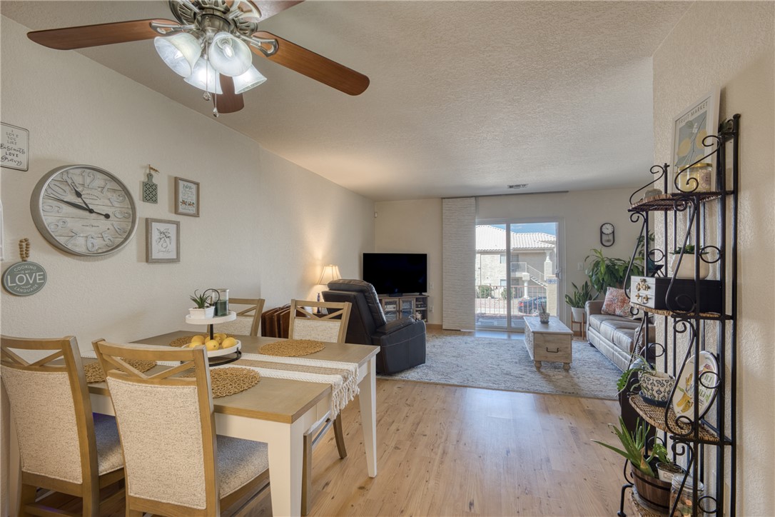 3400 Sunriver Road, Unit D2 Bullhead City, AZ 86429 - Photo 8 of 61 Open concept living area featuring hardwood flooring in the dining space and carpet in the living room, a ceiling fan with integrated lighting, and sliding glass doors leading to an outdoor area
