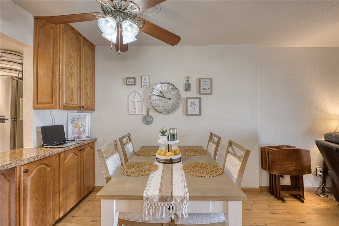 3400 Sunriver Road, Unit D2 Bullhead City, AZ 86429 - Photo 9 of 61 This dining area features a wood dining table with seating, light wood flooring, and a ceiling fan with integrated lighting