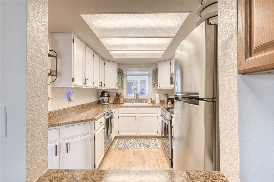 3400 Sunriver Road, Unit D2 Bullhead City, AZ 86429 - Photo 11 of 61 The kitchen features white cabinetry, stone countertops, and stainless steel appliances