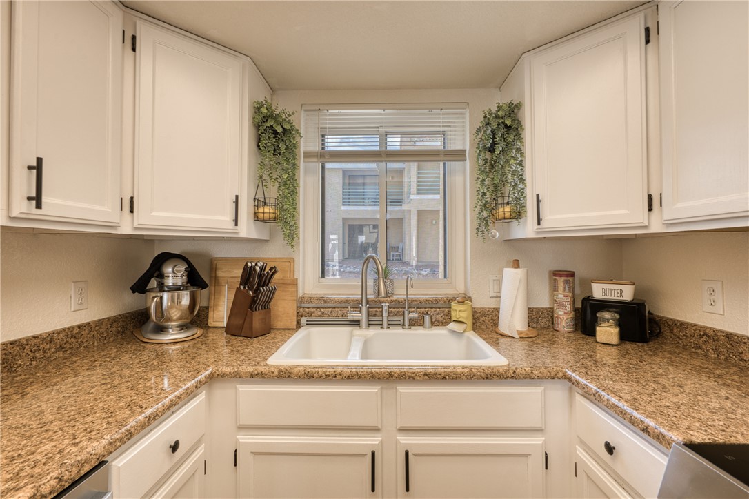 3400 Sunriver Road, Unit D2 Bullhead City, AZ 86429 - Photo 14 of 61 Kitchen featuring white cabinetry with dark hardware, a double basin sink, and ample counter space with a brown patterned finish