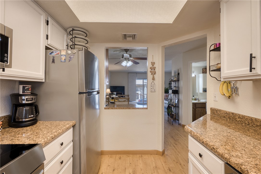 3400 Sunriver Road, Unit D2 Bullhead City, AZ 86429 - Photo 15 of 61 The kitchen features white cabinetry with black hardware, granite countertops, and light wood flooring