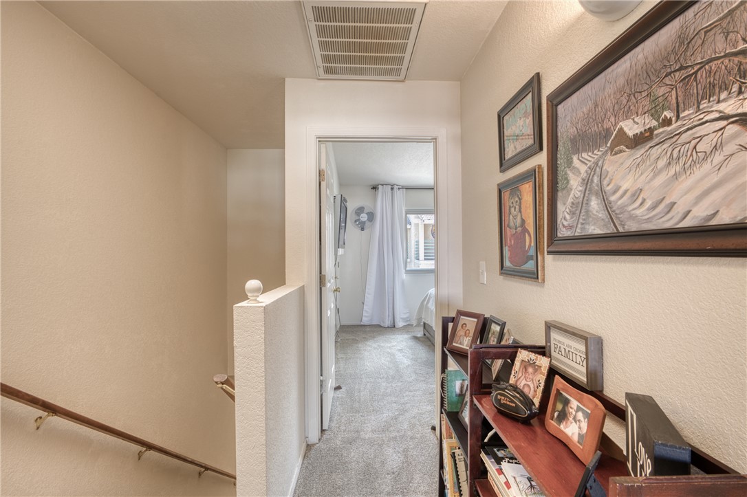 3400 Sunriver Road, Unit D2 Bullhead City, AZ 86429 - Photo 17 of 61 The property features a hallway with light-colored walls and carpeted flooring, leading towards a room with a visible window