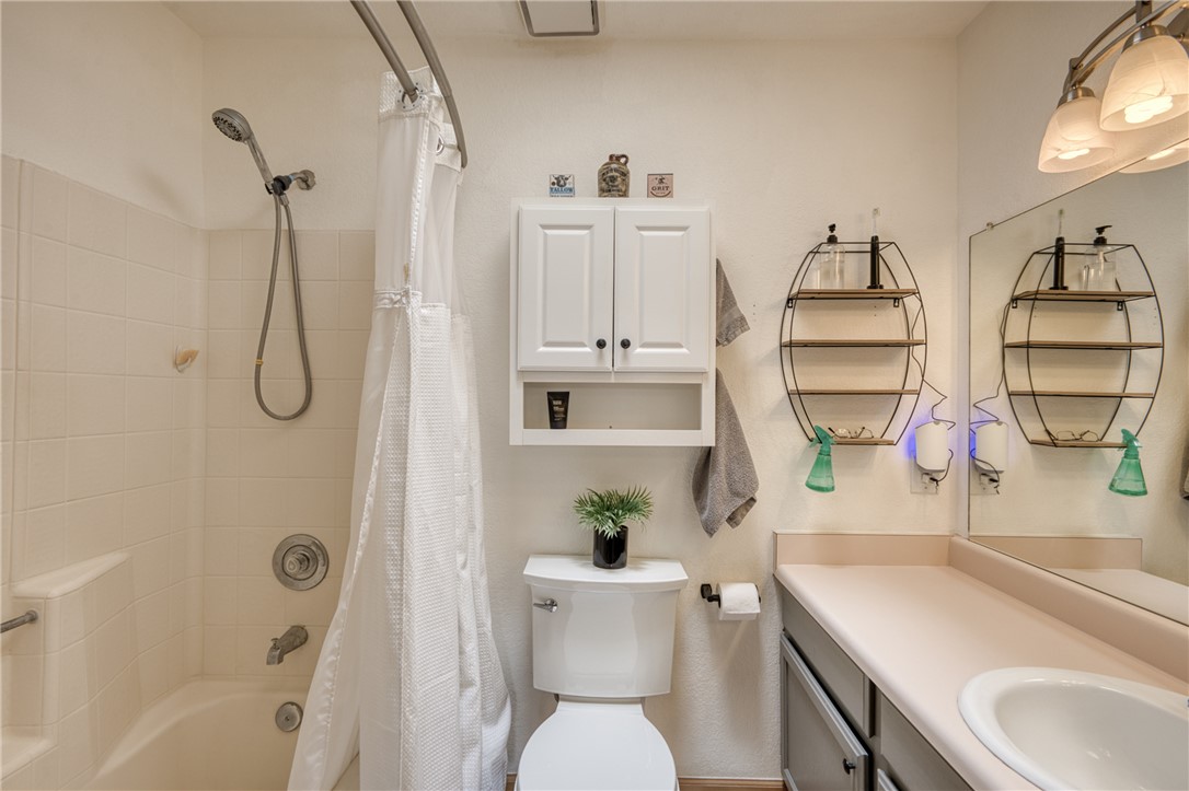 3400 Sunriver Road, Unit D2 Bullhead City, AZ 86429 - Photo 36 of 61 The bathroom features a bathtub and shower combination with a curved shower rod, a vanity with a single sink, and a wall-mounted medicine cabinet