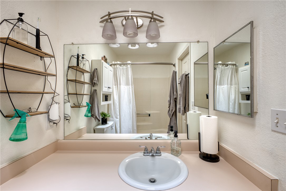 3400 Sunriver Road, Unit D2 Bullhead City, AZ 86429 - Photo 38 of 61 Bathroom vanity featuring a single sink, a large mirror, and a wall-mounted light fixture with three glass shades