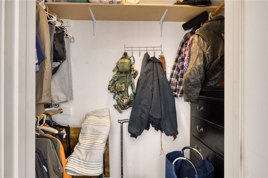 3400 Sunriver Road, Unit D2 Bullhead City, AZ 86429 - Photo 39 of 61 The closet features a built-in shelf, wall-mounted hanging racks, and a dark-toned dresser for storage